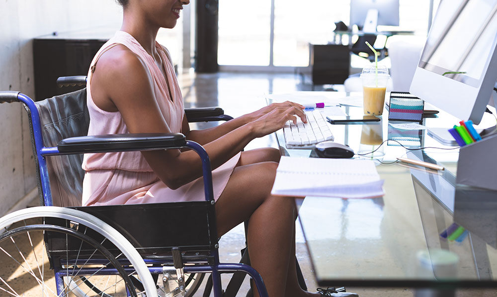 woman at desk in wheelchair, disability discrimination