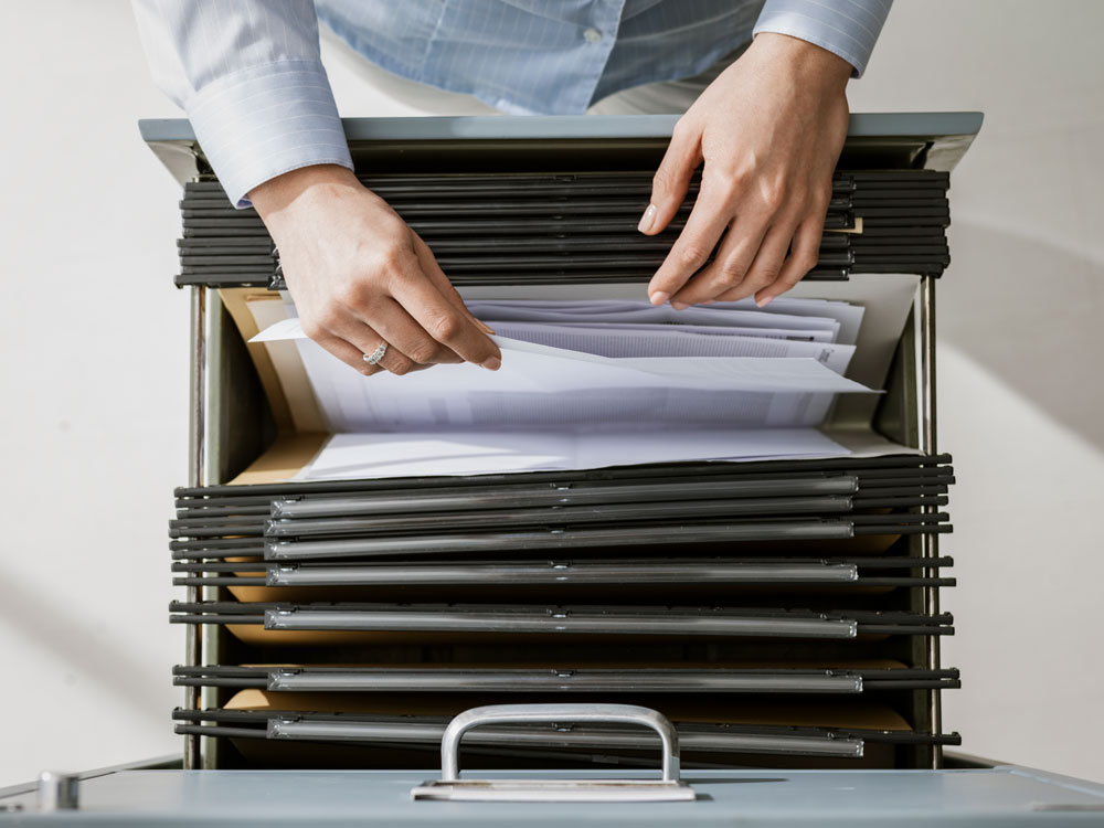 woman looking through folders of personnel files